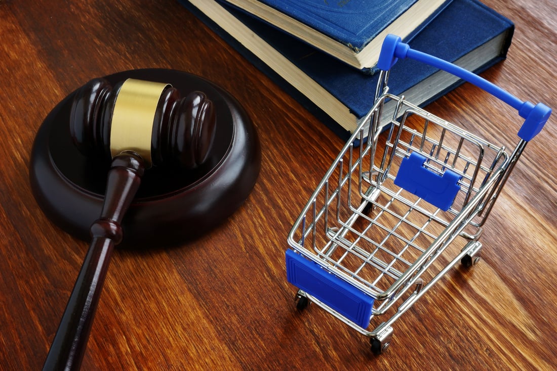 Consumer protection law concept. Shopping cart and gavel.